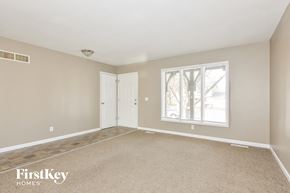 Florissant house for rent - A room with a carpeted floor, a window, and a door.