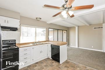 Florissant house for rent - A kitchen with a black stove top oven and a black dishwasher.