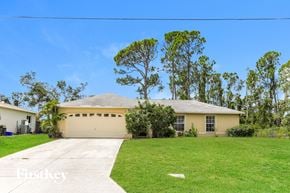 North Port house for rent - a yellow house with a lawn and a driveway
