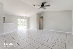 North Port house for rent - an empty living room with a ceiling fan and tiled floor