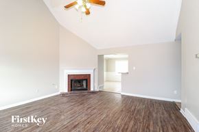 Cordova house for rent - A spacious room with a fireplace and wood flooring.