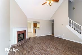 Cordova house for rent - A spacious living room with a fireplace and wooden floors.