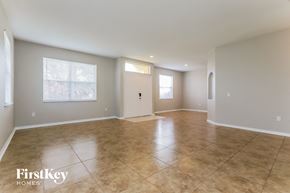 Lakeland house for rent - A spacious room with tile flooring and a door in the middle.