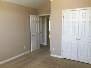 Ellenwood house for rent - a bedroom with two closets and a door to a hallway