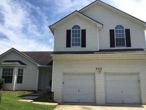 Ellenwood house for rent - a white house with two garage doors and a roof