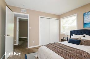 Florissant house for rent - A bedroom with a large bed and a painting on the wall.