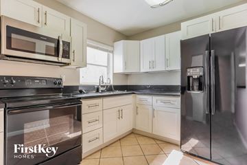 Homestead house for rent - a kitchen with stainless steel appliances and white cabinets