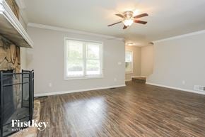 Austell house for rent - an empty living room with a ceiling fan and a fireplace