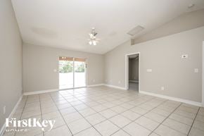 Lehigh Acres house for rent - A spacious room with a sliding glass door leading to a balcony.