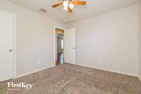 Royse City house for rent - a bedroom with a ceiling fan and a carpeted floor