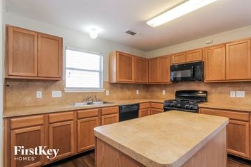 Richmond house for rent - a kitchen with wooden cabinets and a counter top
