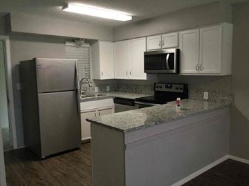 Corinth house for rent - a kitchen with a granite counter top and a stainless steel refrigerator