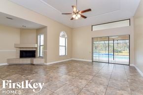 Plant City house for rent - an empty living room with a fireplace and a ceiling fan