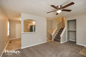Conyers house for rent - an empty living room with a ceiling fan and a staircase