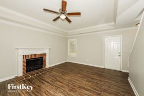 Helena house for rent - A room with a fireplace and a ceiling fan.