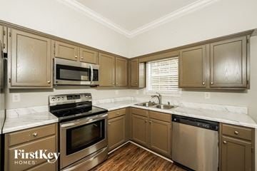 Helena house for rent - A kitchen with wooden cabinets and stainless steel appliances.