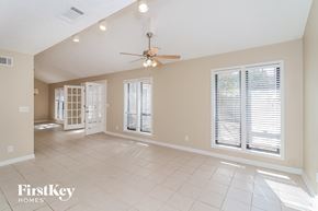 Marietta house for rent - an empty living room with a ceiling fan and windows