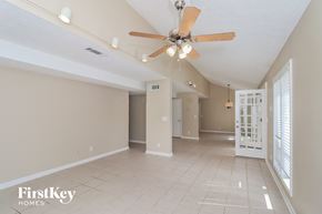 Marietta house for rent - a spacious living room with a ceiling fan and a tiled floor