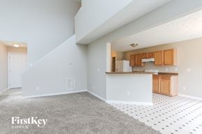 Raleigh house for rent - A spacious kitchen and living room with a staircase leading to the upper floor.