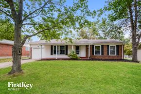 Florissant house for rent - a white and brick house with a lawn and trees