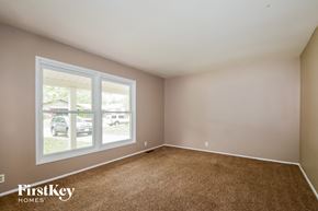 Florissant house for rent - an empty bedroom with a large window and carpet