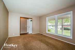Florissant house for rent - an empty living room with a large window and carpet