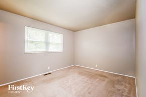 Florissant house for rent - a bedroom with a large window and a carpeted floor
