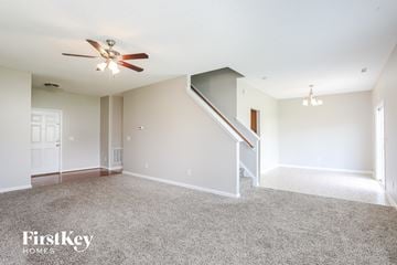 Raleigh house for rent - a living room with carpet and a ceiling fan