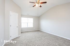 Raleigh house for rent - a bedroom with white carpet and a ceiling fan
