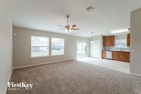 Middleburg house for rent - an empty living room with a ceiling fan and a kitchen