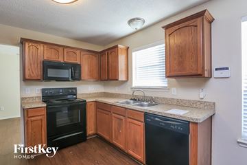Lancaster house for rent - A kitchen with wooden cabinets and black appliances.