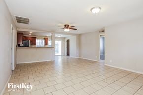 Phoenix house for rent - A spacious living room with a fan and a television.