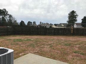 Lawrenceville house for rent - a backyard with a wooden fence and a grass field