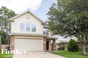 Houston house for rent - a white house with a garage door and a tree