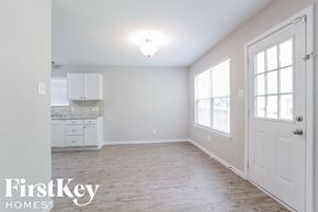 Houston house for rent - a white kitchen with white cabinets and a wood floor