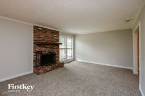 Marietta house for rent - the living room of an empty house with a brick fireplace