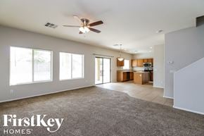 Queen Creek house for rent - an empty living room with a ceiling fan and a kitchen