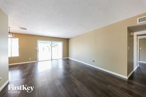 Phoenix house for rent - an empty living room with wood floors and a door to a patio