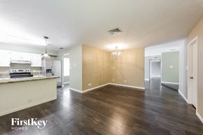 Phoenix house for rent - an empty living room and kitchen with wood flooring and white walls