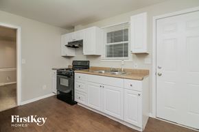 Zion house for rent - a kitchen with white cabinets and a sink and a stove