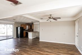 Plano house for rent - A spacious room with wooden floors and a ceiling fan.