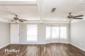 Plano house for rent - A room with wooden floors and two ceiling fans.