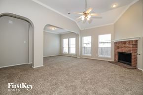 Denton house for rent - a living room with a brick fireplace and a ceiling fan