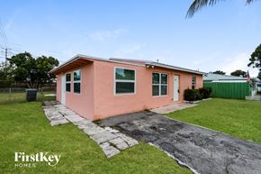 Lake Worth house for rent - A pink house with a stone pathway leading to the front door.