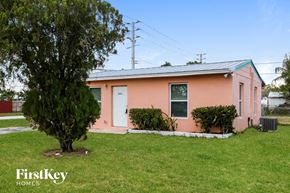 Lake Worth house for rent - A pink house with a tree in front of it.
