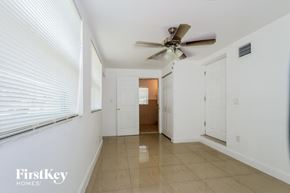 Lake Worth house for rent - A spacious hallway with a ceiling fan and two doors.