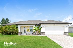 Cape Coral house for rent - a white house with a lawn and a garage door