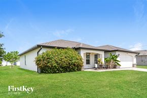Cape Coral house for rent - a white house with a yard and a green lawn