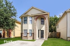 Houston house for rent - the front of a house with a driveway and grass