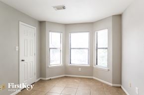 Houston house for rent - a living room with three windows and a white door